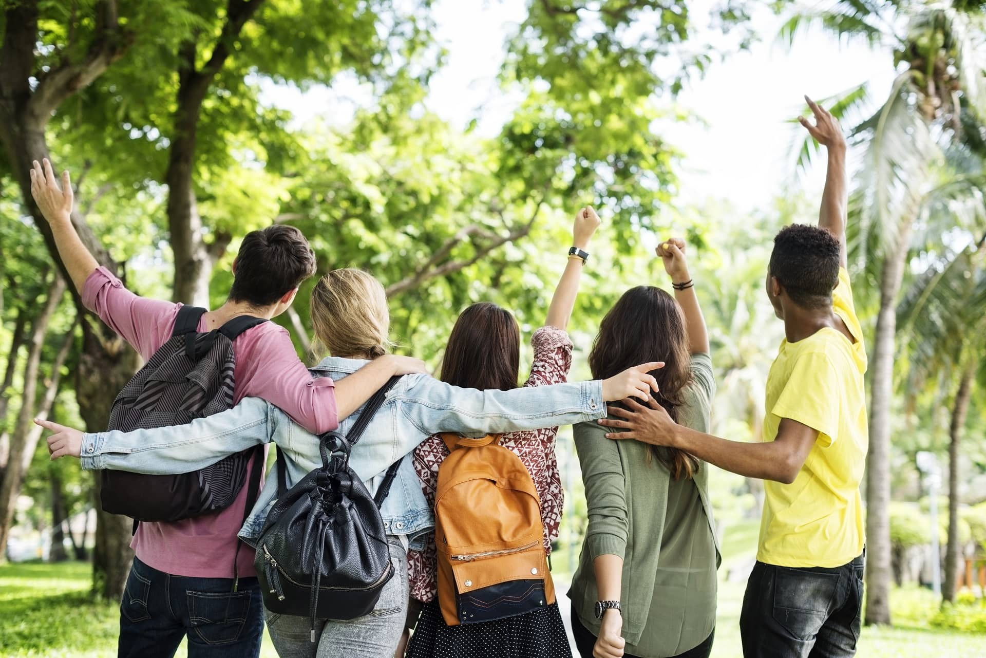Gruppo di adolescenti che camminano insieme in un parco, simbolo di amicizia e condivisione durante l’adolescenza.